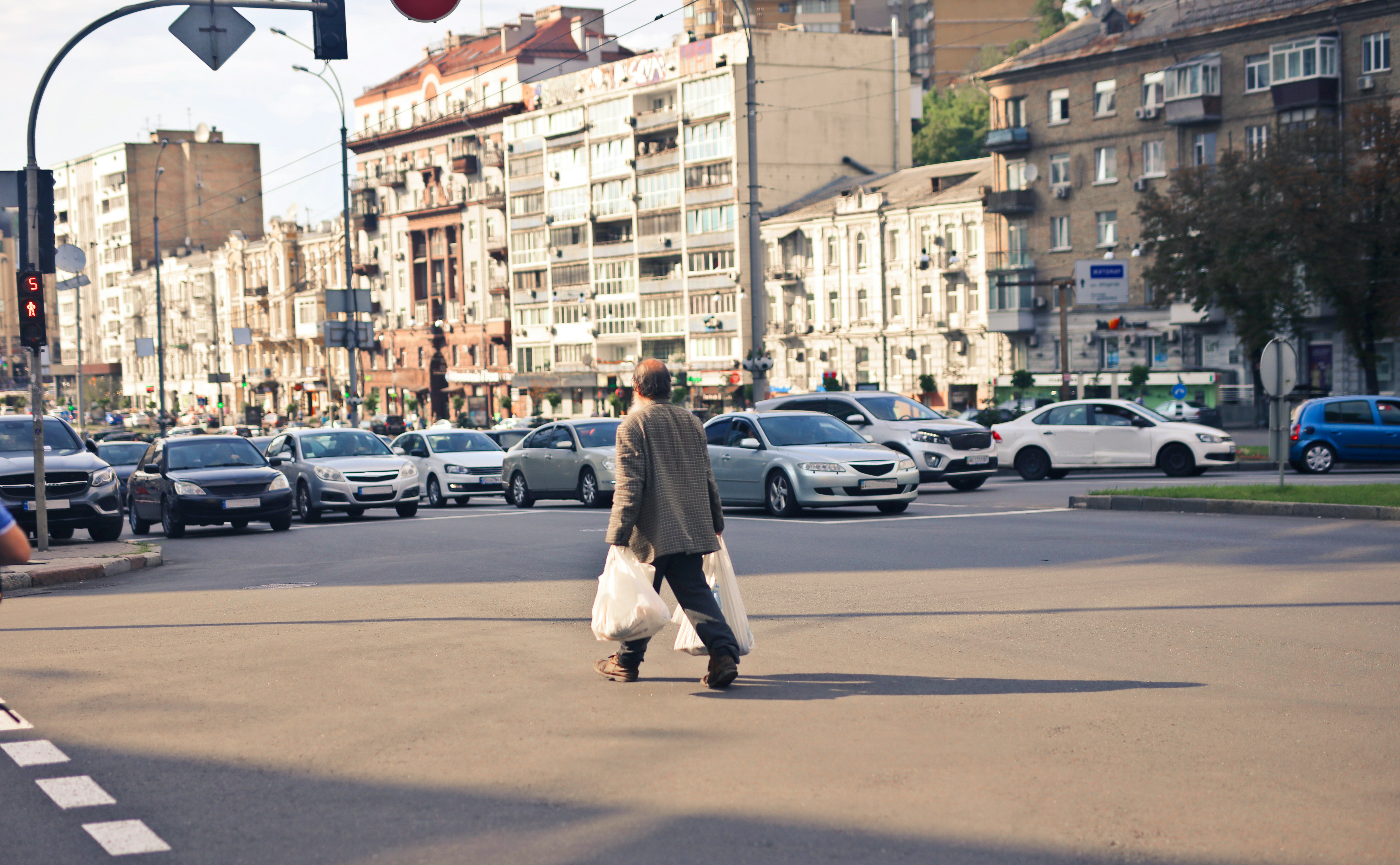 person wearing beige jacket walking on street